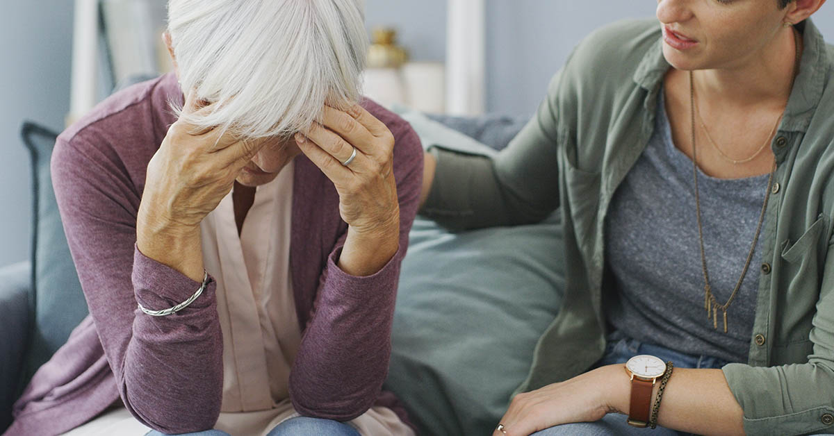 woman being comforted with hand placed on her back