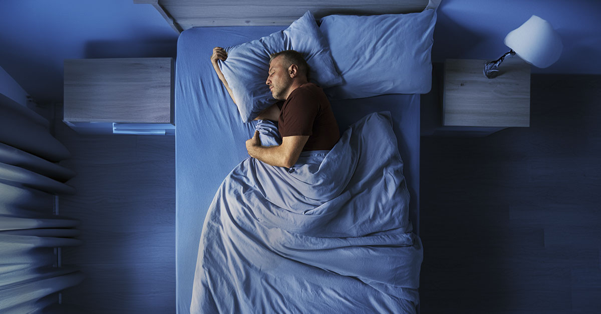 person sleeping in bed on their side, seen from above