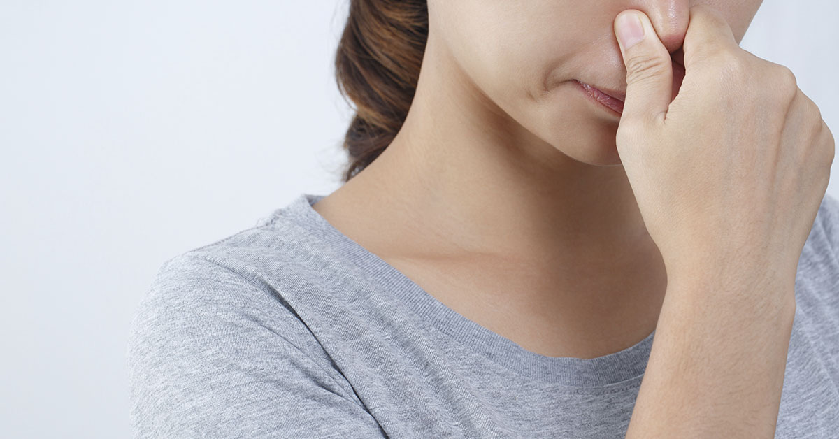 Woman plugging her nose with fingers. Off putting smell concept