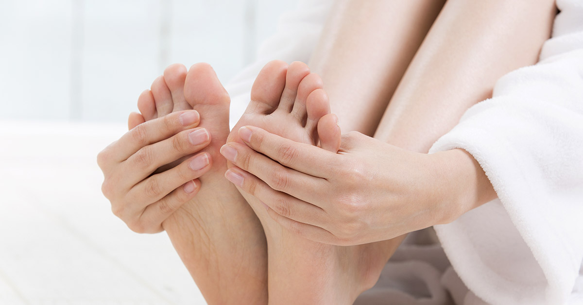 woman holding and massaging ends of sore feet