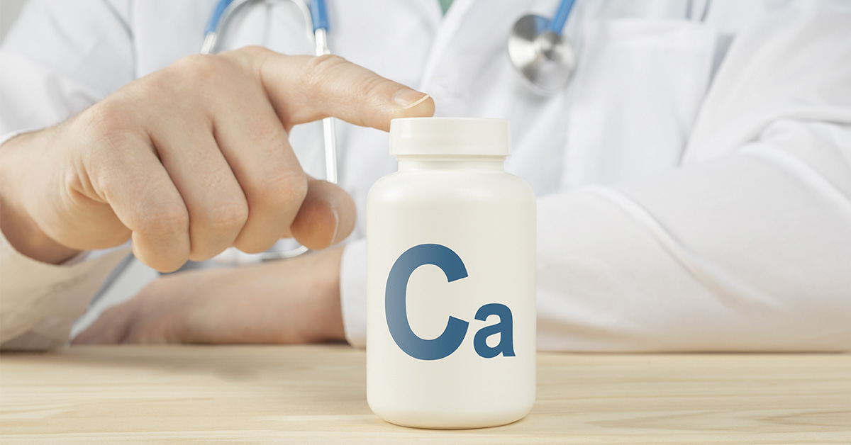 Man placing finger on tob of white bottle labelled Ca (Calcium). Nutritions and Electrolyte concept