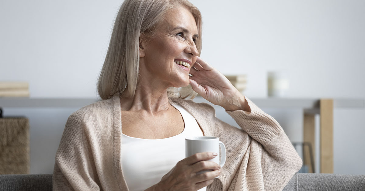 Happy middle aged woman drinking a cup of coffee