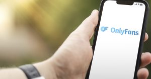 person holding a phone with OnlyFans displayed on screen