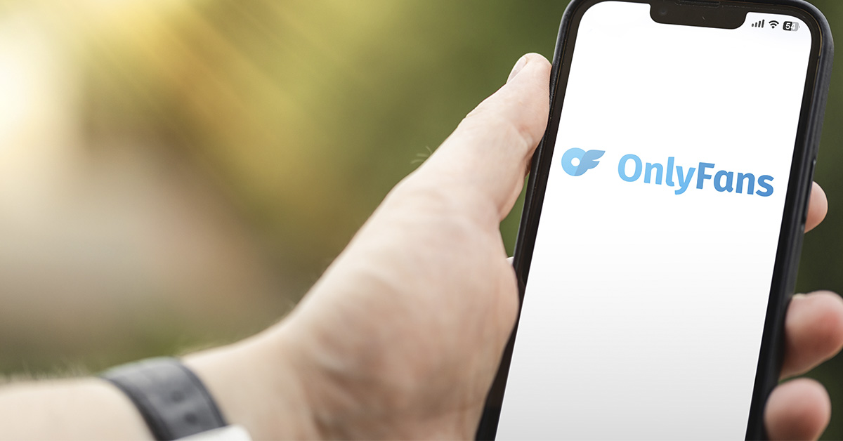 person holding a phone with OnlyFans displayed on screen