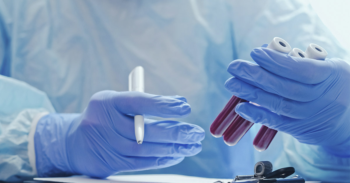 Blood test. Clinic laboratory. Nurse studying serum samples recording results with hands in medical protective rubber gloves with tubes and pen.