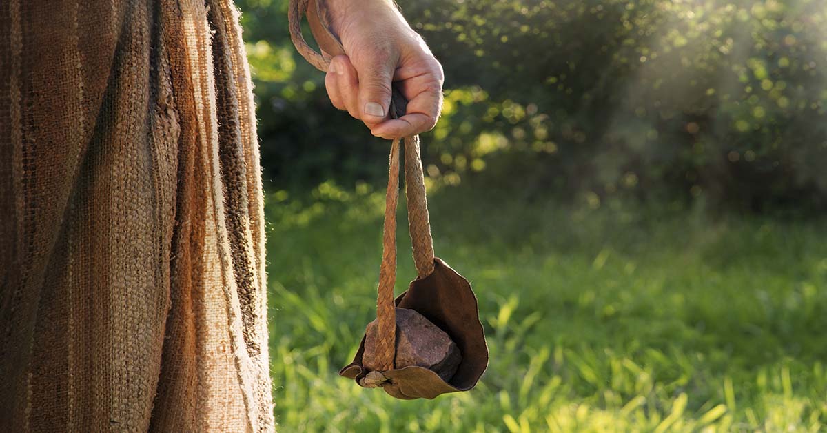 hand holding a sling, a weapon used to throw projectiles. The sling was famously used by David to defeat Goliath in the biblical story.