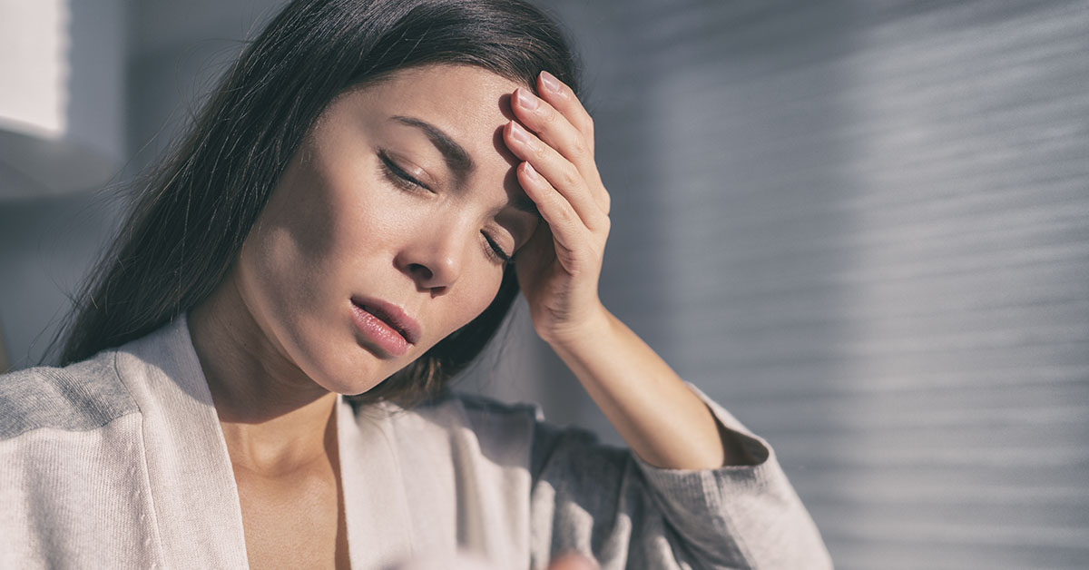 woman with hand on head due to heartache