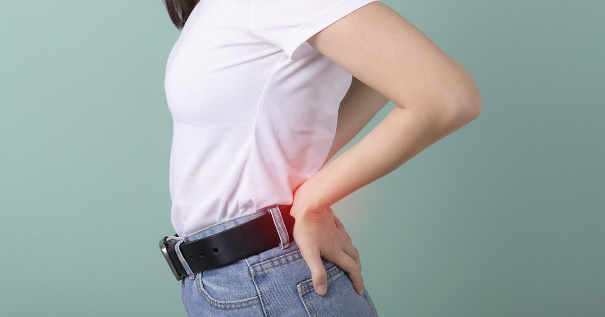 woman holding her lower back due to back pain