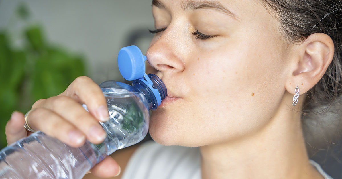 woman sipping bottled water