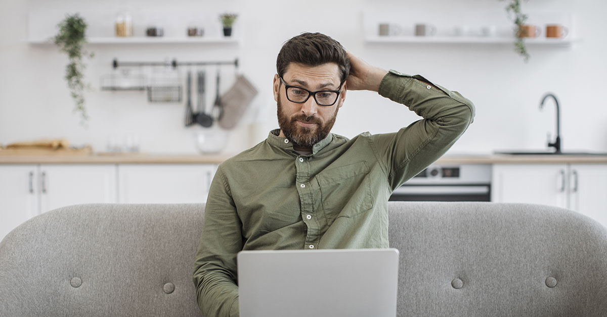 confused man looking at a laptop screen