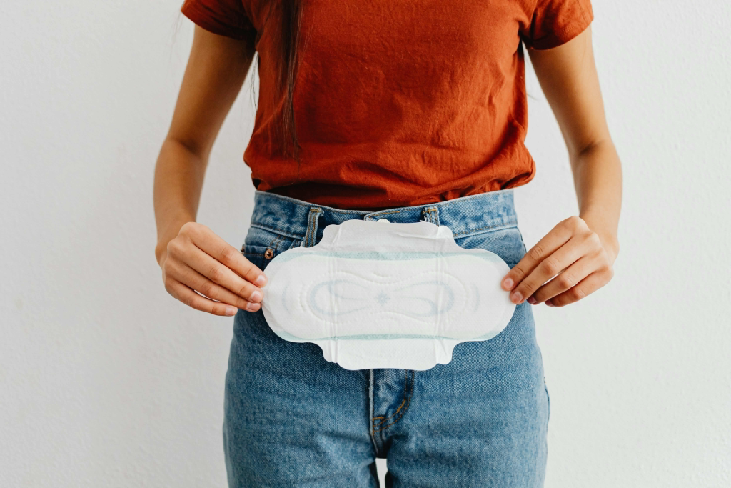 Hands holding a regular sanitary pad, representing the future smart pad technology.