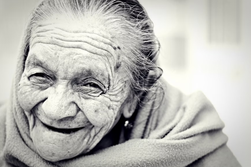 Eldery woman smiling with a scarf wraped around her neck