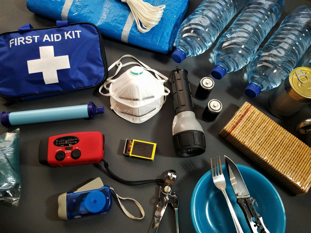 Emergency preparedness supplies including first aid kit, water bottles, flashlight, and radio.
