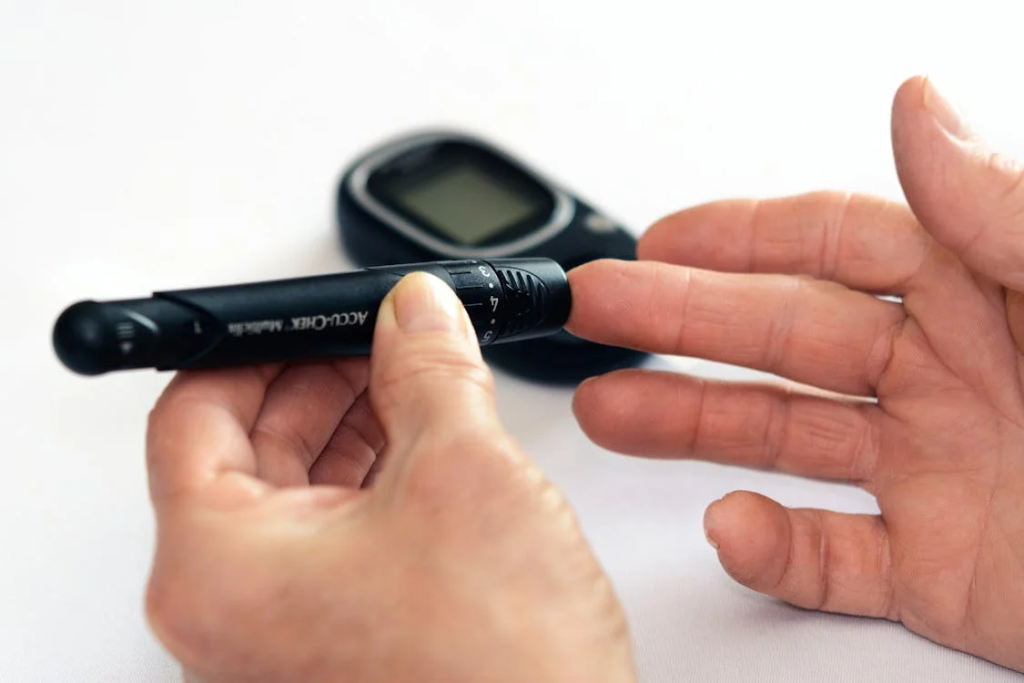 Hands performing a blood glucose test with a digital meter and testing strip.