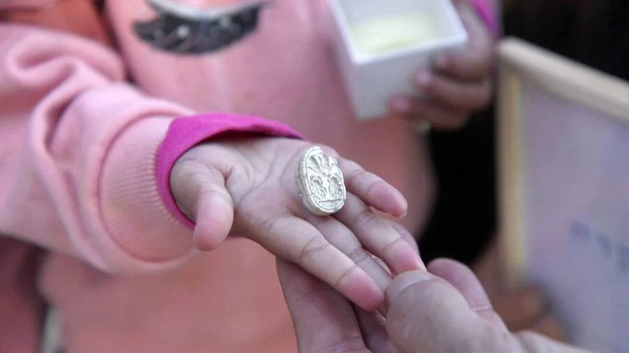 Three-year-old Ziv holds her discovery a the David and Goliath site.