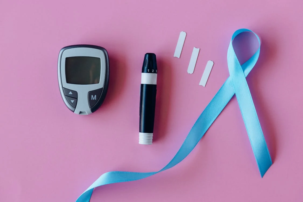 Glucometers Near Blue Ribbon on Pink Surface