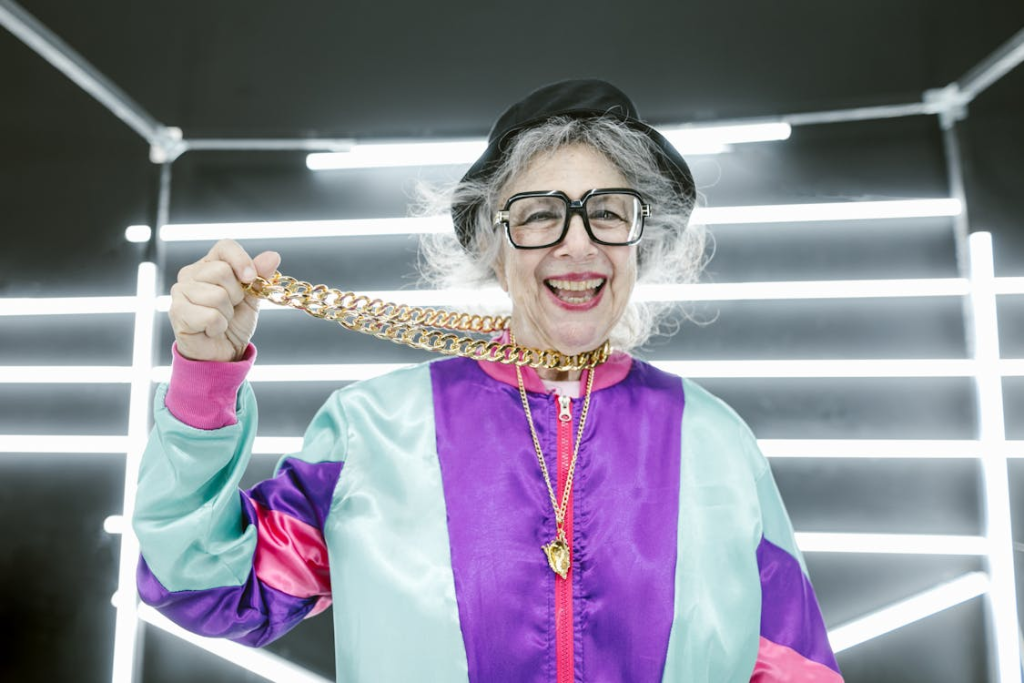 Woman in Purple and Pink Long Sleeve Jacket Holding Gold Necklace
