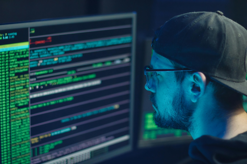 Person working on computer with code displayed on screen.