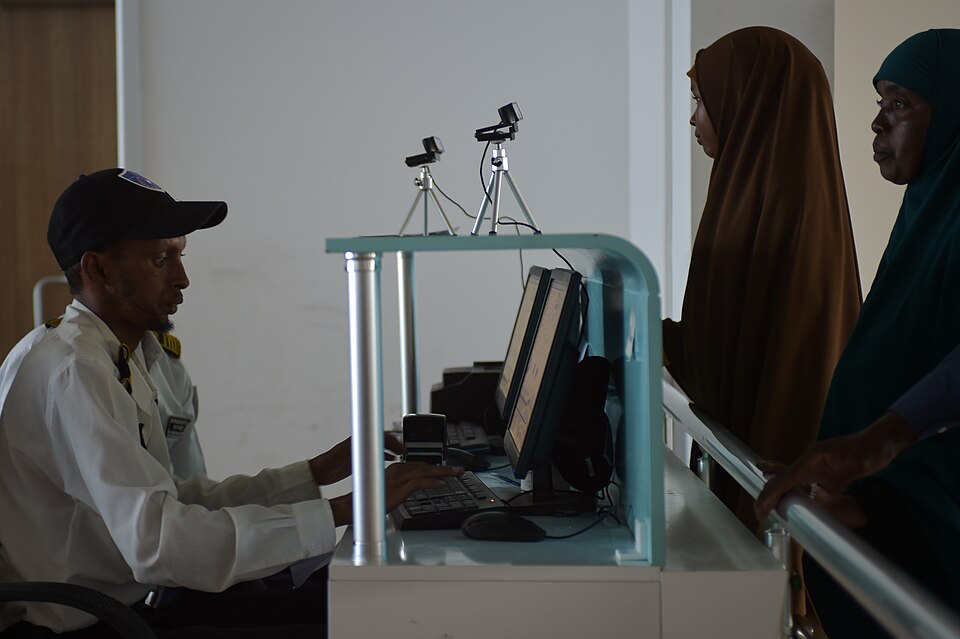 Airport security officer scanning passenger identification documents.