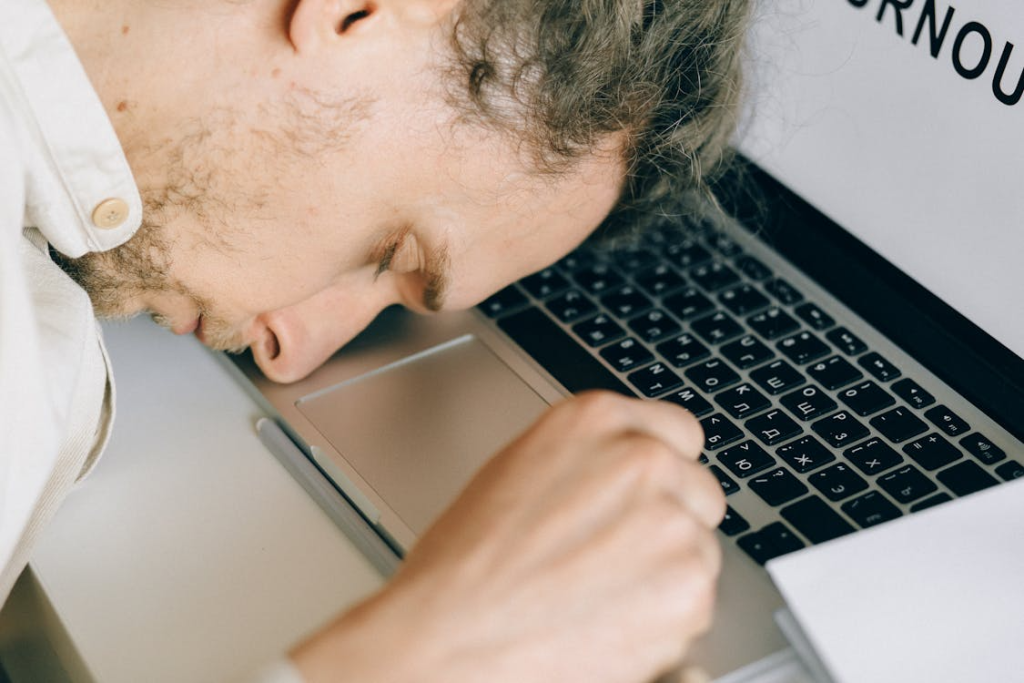 Overworked Employee lying in front of Laptop