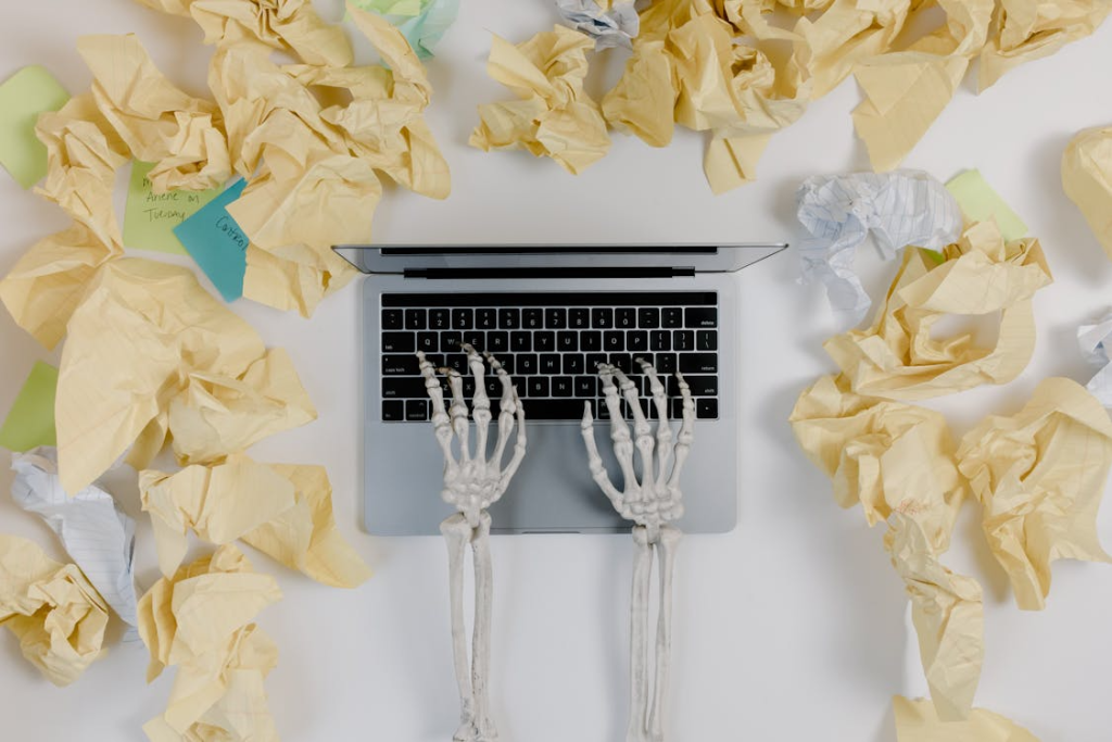 Crumpled Papers Beside a Laptop