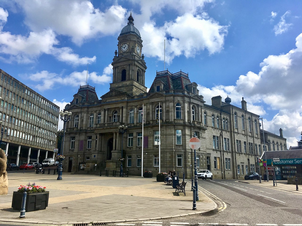 Historic town hall with clock tower in Dewsbury, Yorkshire, where Brendon Grimshaw grew up before buying his tropical island.