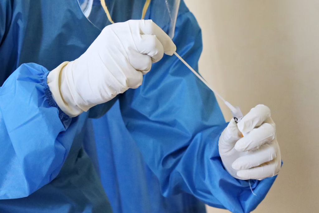 Healthcare worker preparing a nasal swab test, the key tool for detecting the new Nimbus COVID variant causing razor blade throat.