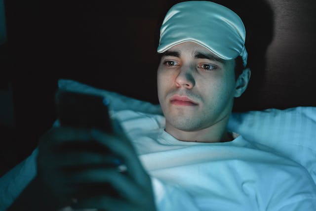 man in bed on phone