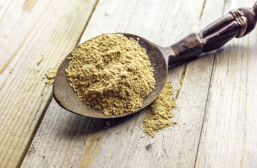 Spoon with Kava Kava root powder on wooden table