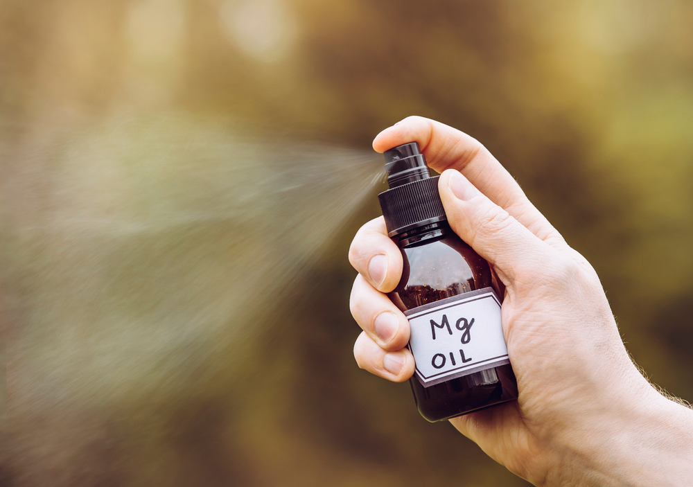 Using Magnesium Oil providing the body with sufficient magnesium vitamin. Spraying liquid magnesium oil on skin.