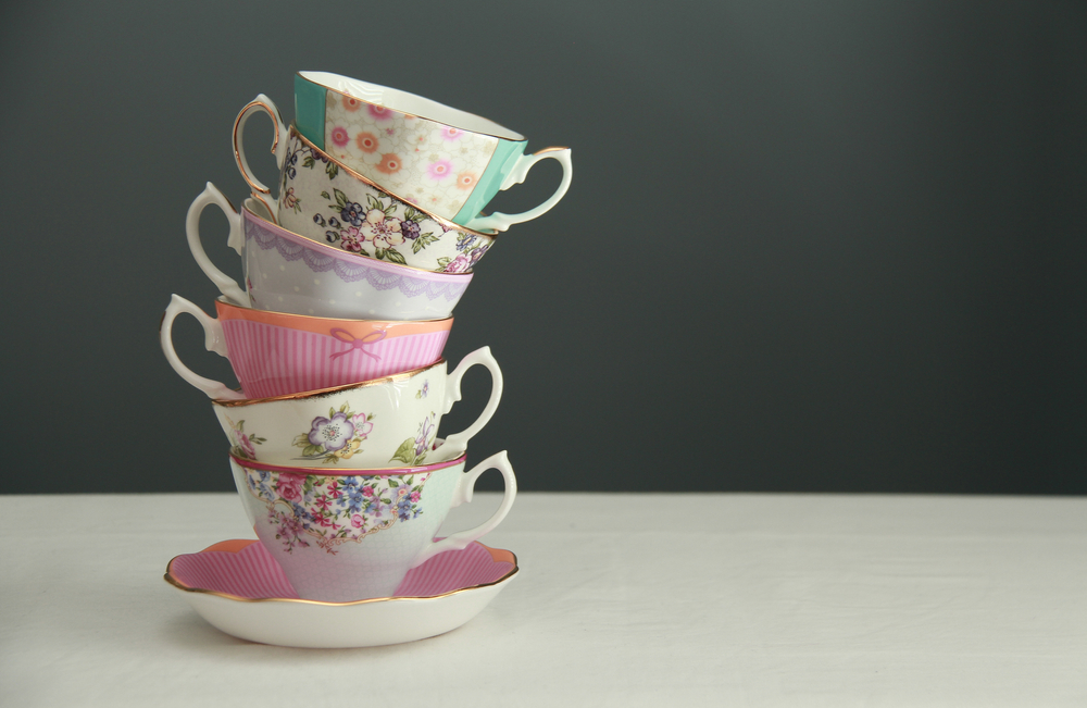 Fine bone China made in England tea cups stacked in a column with a blue-grey background