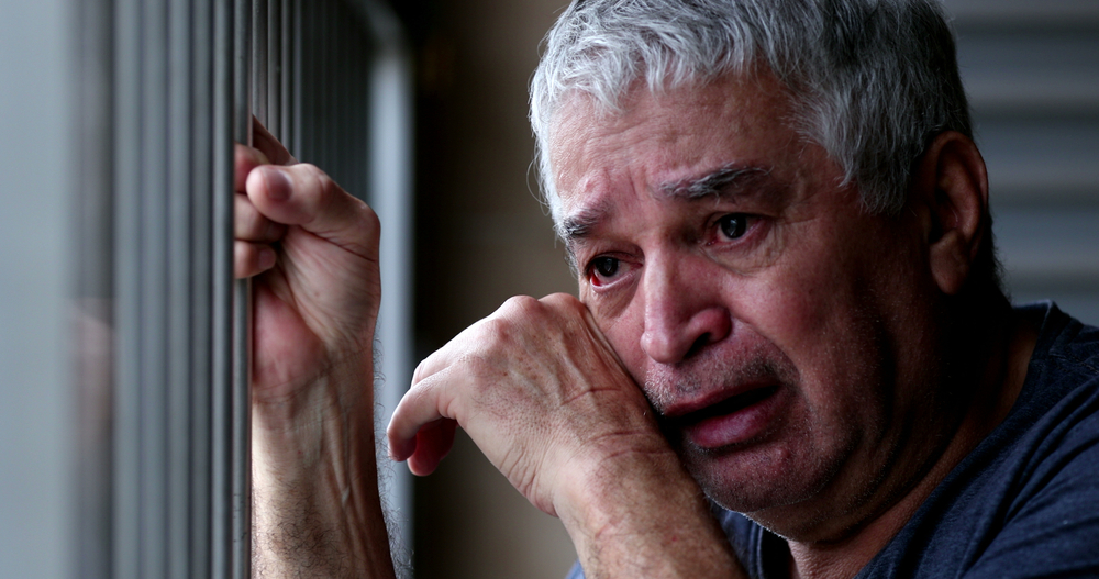 Older man crying with grief and pain. Senior person suffering alone