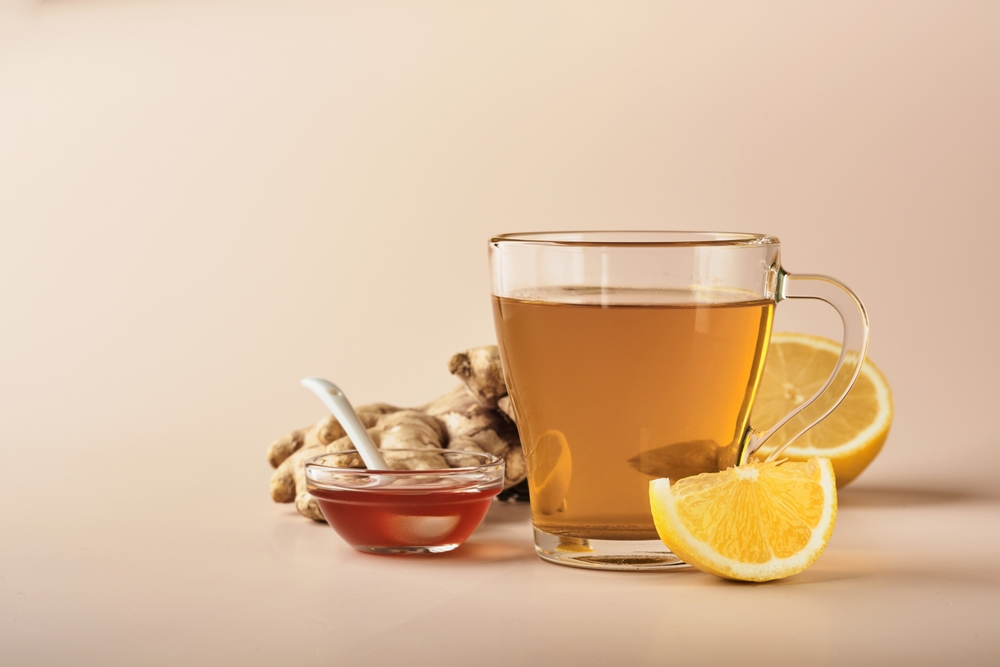 Ginger tea. Cup of ginger tea with lemon, honey and mint on beige background. Concept alternative medicine, natural homemade remedy for cold and flu. Top view. Free space for your text.