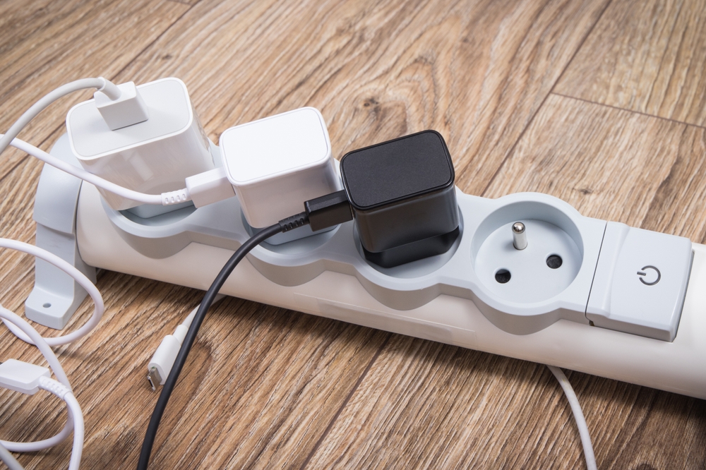 Smartphone, mobile phone chargers connected to electrical power strip. Various devices charging concept

