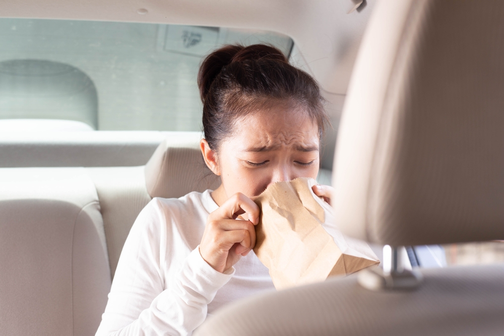 Asian woman experiencing motion sickness and vomiting during travel, vomit bags, nausea, travel sickness