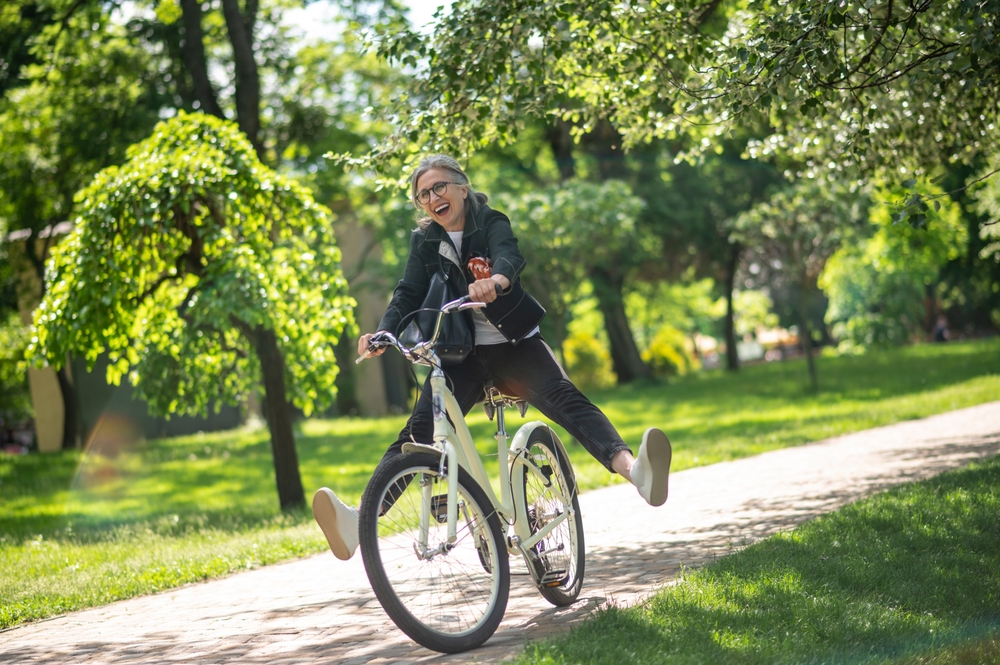 A woman in black clothes riding a bike and having fun