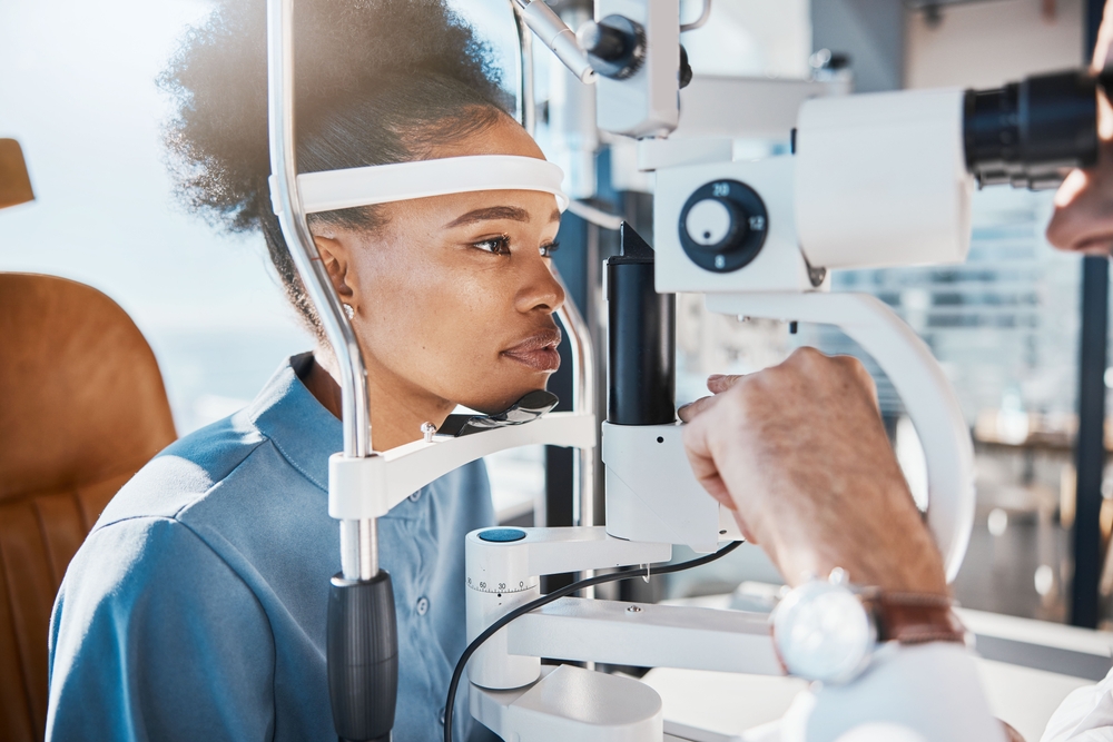 Eye exam or black woman consulting doctor for eyesight at optometrist or ophthalmologist. Face of African customer testing vision with optician helping or testing iris or retina visual health