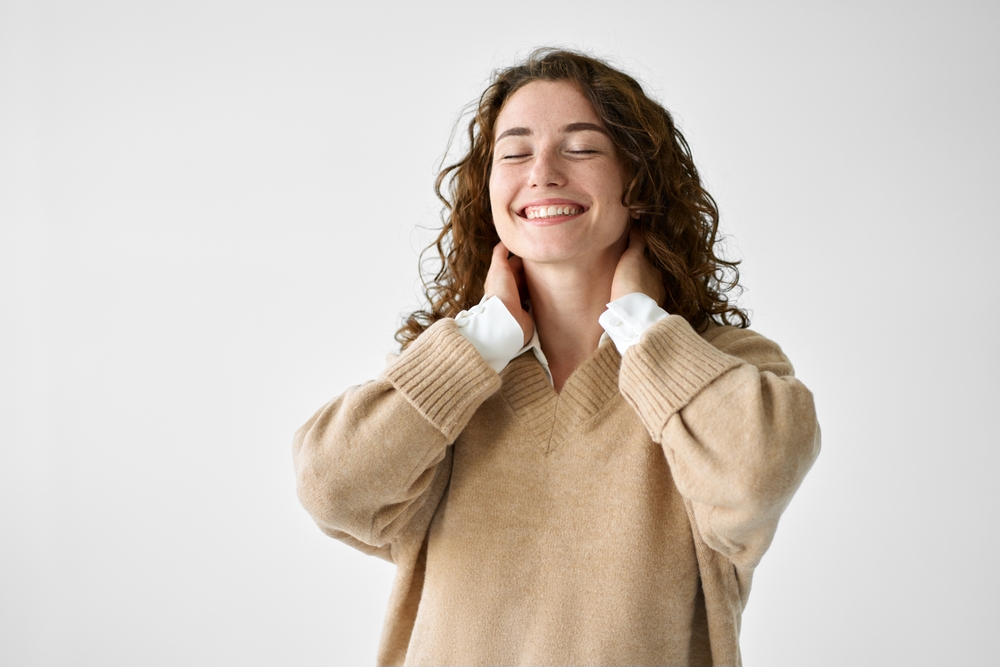 Young adult smiling positive woman model, joyful pretty cheerful cute curly girl student laughing having fun feeling happy healthy standing isolated at white background, authentic candid studio shot.
