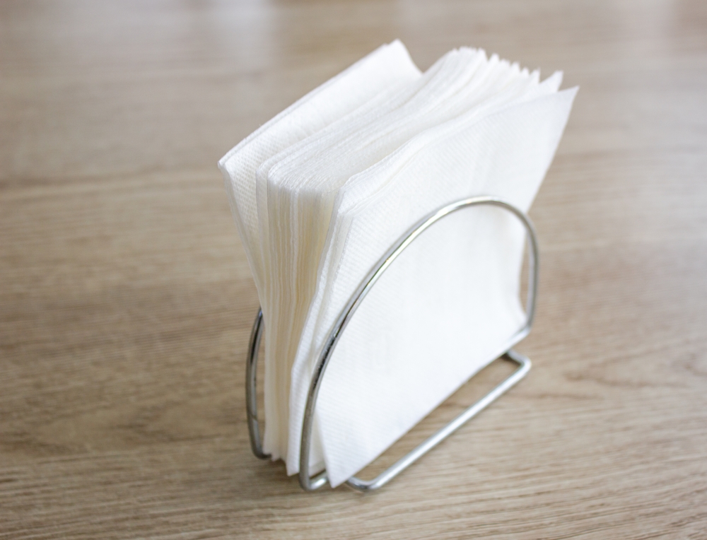 Paper disposable napkins on the table, in a cafe.Disposable sanitary paper napkins.