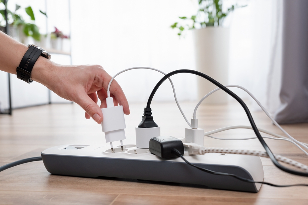 Man plugging the power plug. Electrical plug in outlet socket at home.
