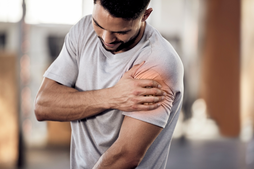 Man, gym or bodybuilder with shoulder pain in workout, training injury or fitness cardio in accident. Red glow, hurt arm muscle or injured athlete in exercise emergency with bruise, ache or agony