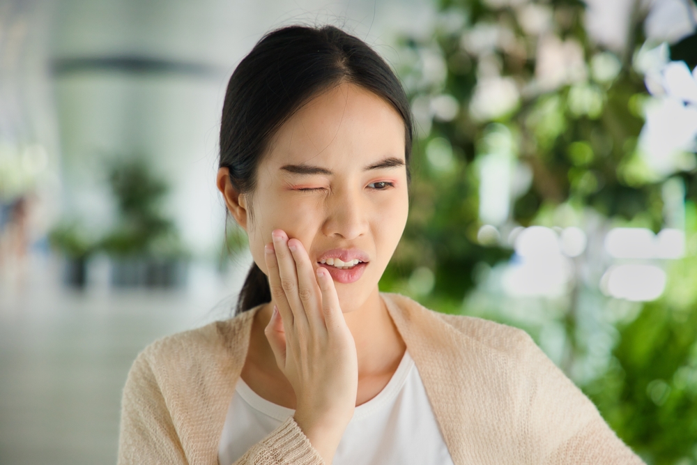 Young Asian woman suffering from toothache, tooth decay, tooth sensitivity, wisdom tooth pain, cavity, dental care concept