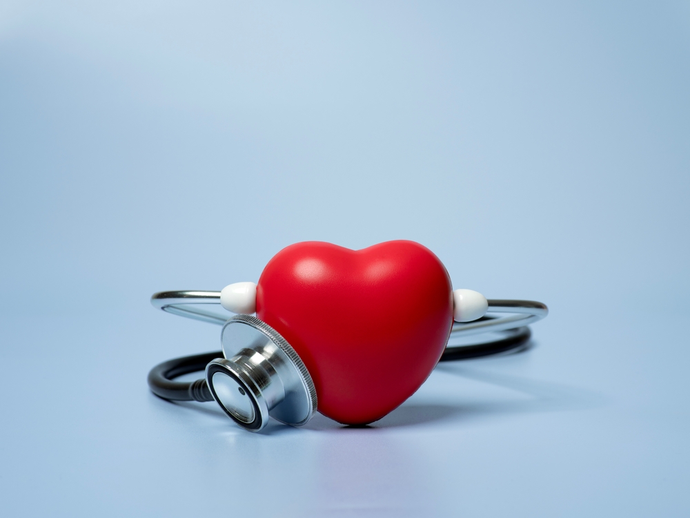 Red heart shape exercise ball with doctor physician's stethoscope on blue background, hospital life insurance concept, world heart health day. doctor day
