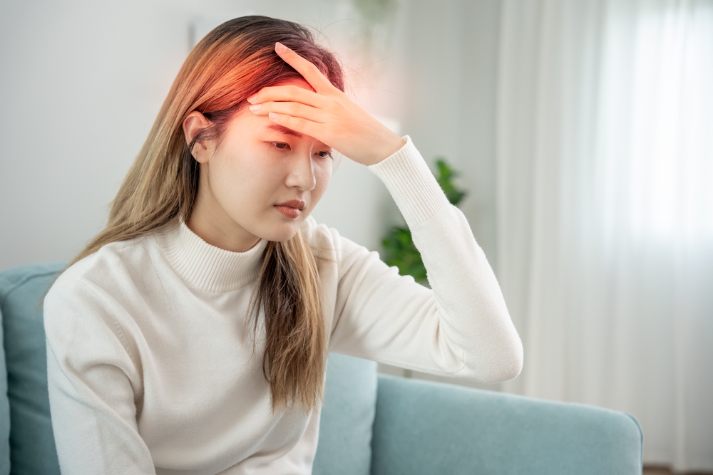 Suffer from headache desperate and stressed because pain and migraine. asian young man suffering migraine pain while working, blue isolated background, brain tumor, high cholesterol effect