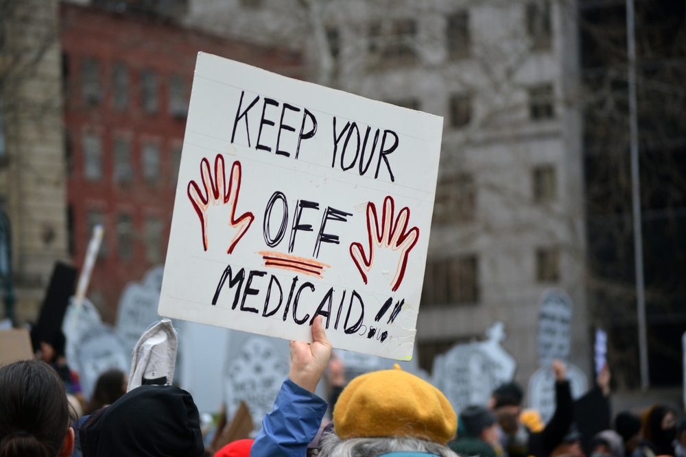 NEW YORK, NEW YORK USA - March 15, 2025: People with signs at a Stop the Cuts rally against DOGE cuts to federal funding in Lower Manhattan.