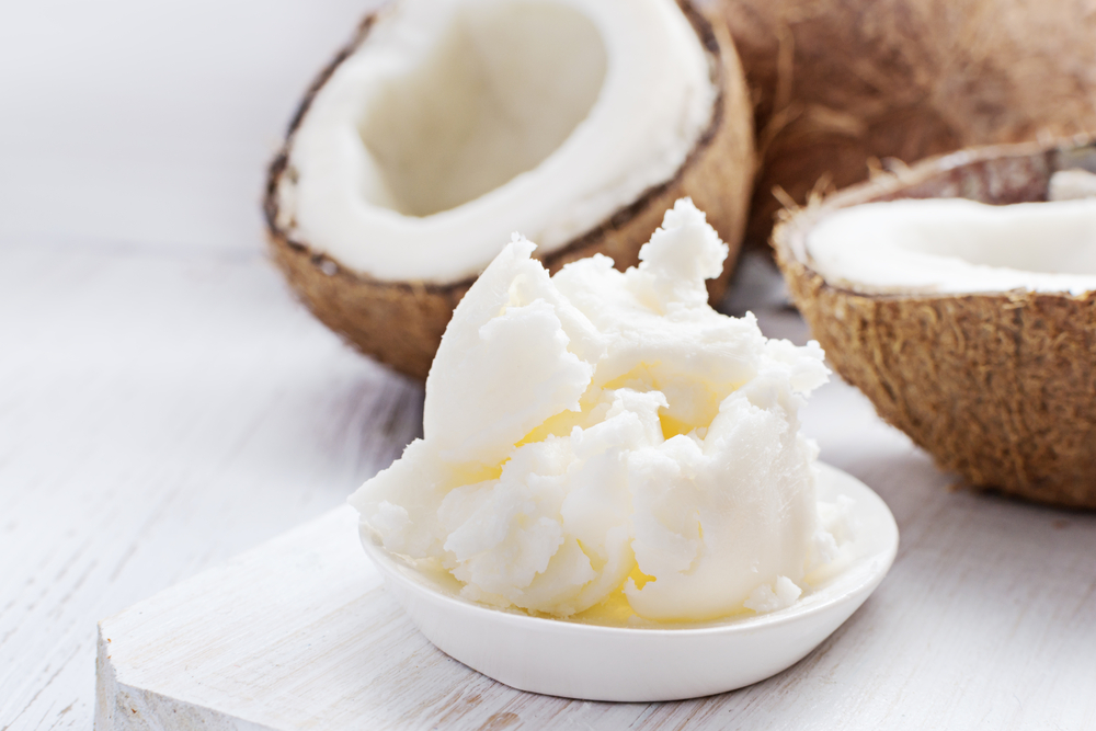 Coconut butter on white wooden background. Organic healthy food concept. Beauty and SPA concept.