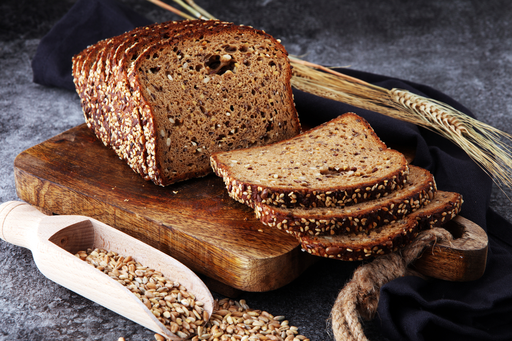 Sliced rye bread on cutting board. Whole grain rye bread with seeds
