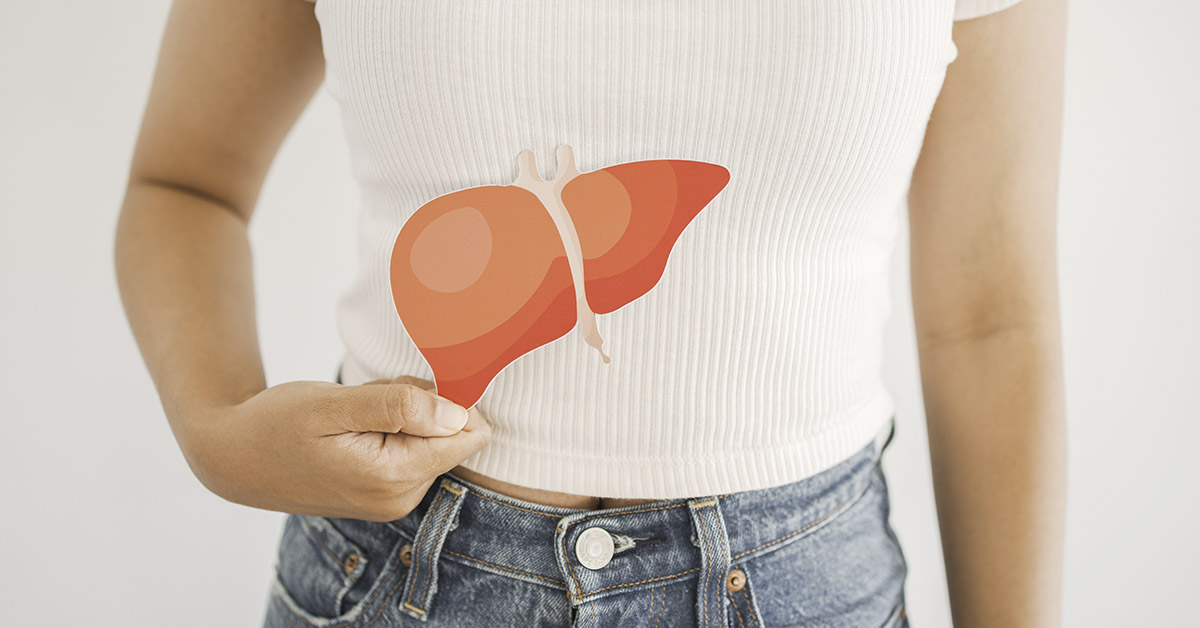 woman with image of liver placed against her abdomen where her liver would be. Liver health concept