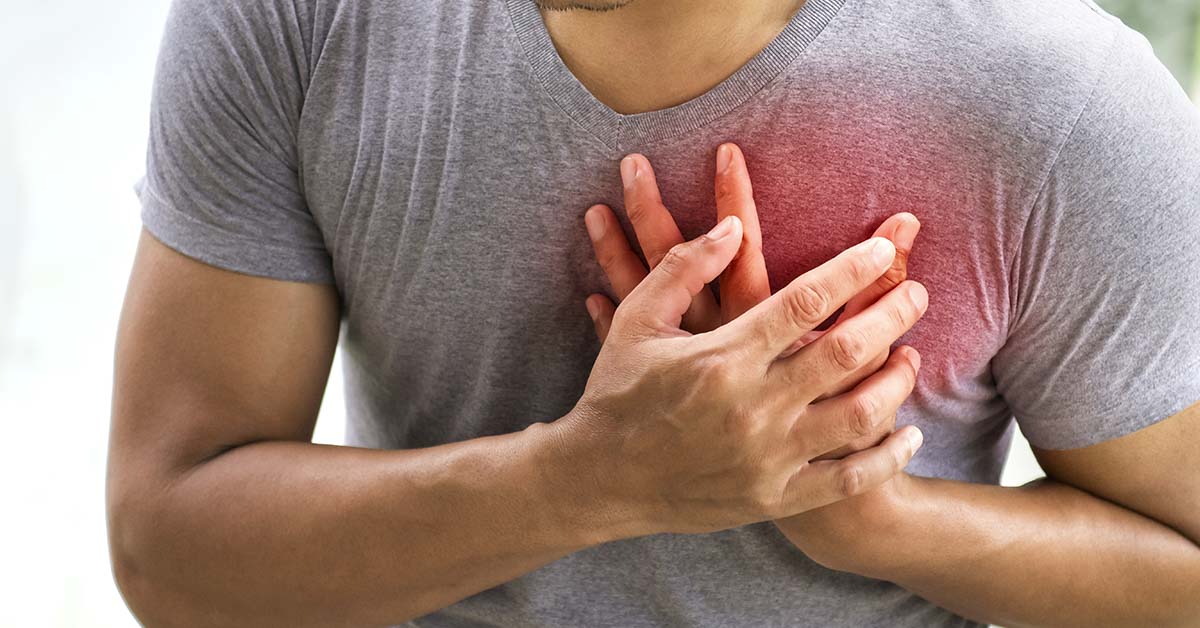 man with hands placed over chest with redness highlighting heart. Heart attack / Heart health concept