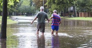 two men walking through flooded area